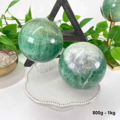 two 800g - 1kg green fluorite spheres on display for possible variations