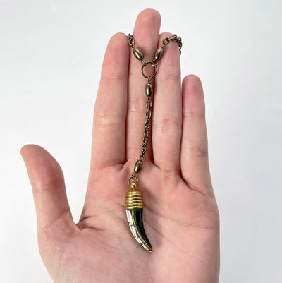 pendant chain and horn pendant in hand for size reference