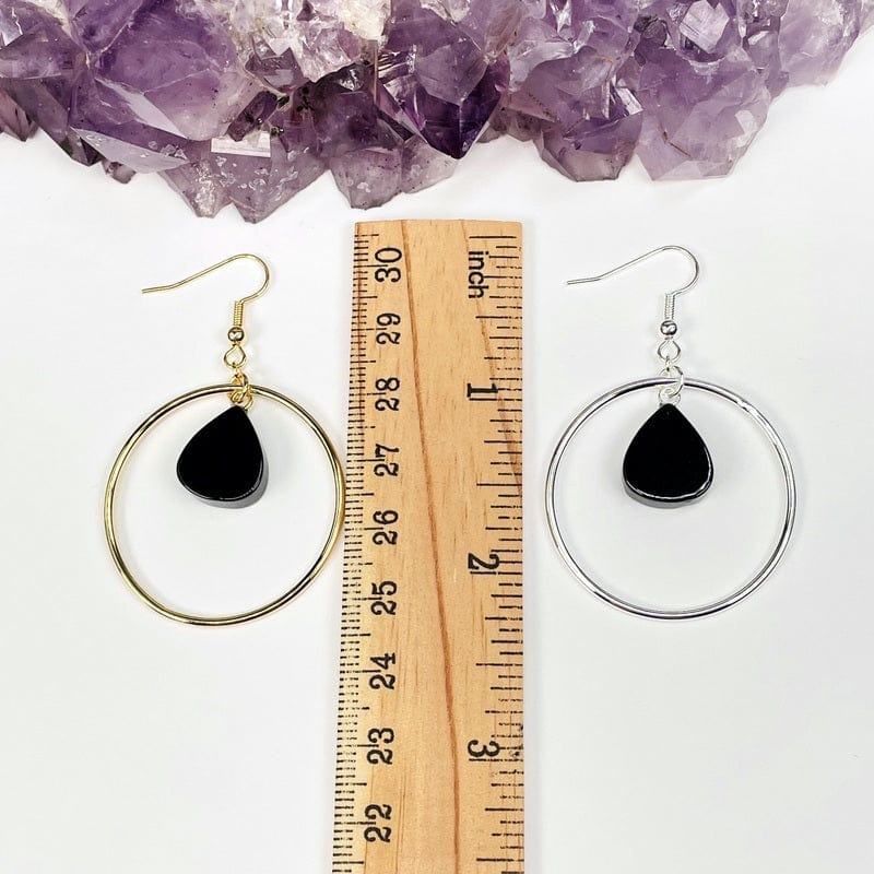 earrings next to a ruler for size reference  