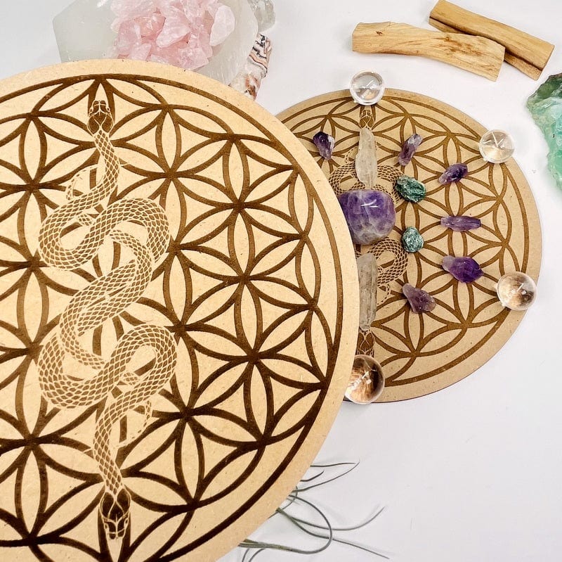 close up of the details on the serpent on flower of life grid that's engraved on wood