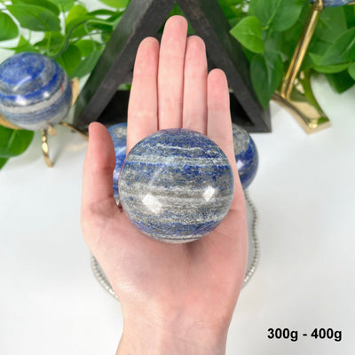 one 300g - 400g lapis lazuli polished sphere in hand 