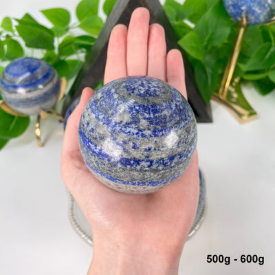one 500g - 600g lapis lazuli polished sphere in hand 