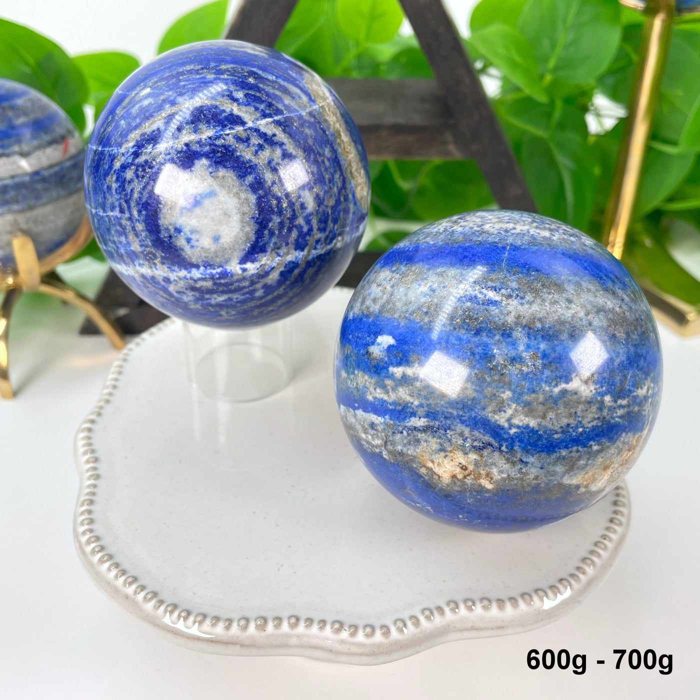 two 600g - 700g lapis lazuli polished sphere on display 