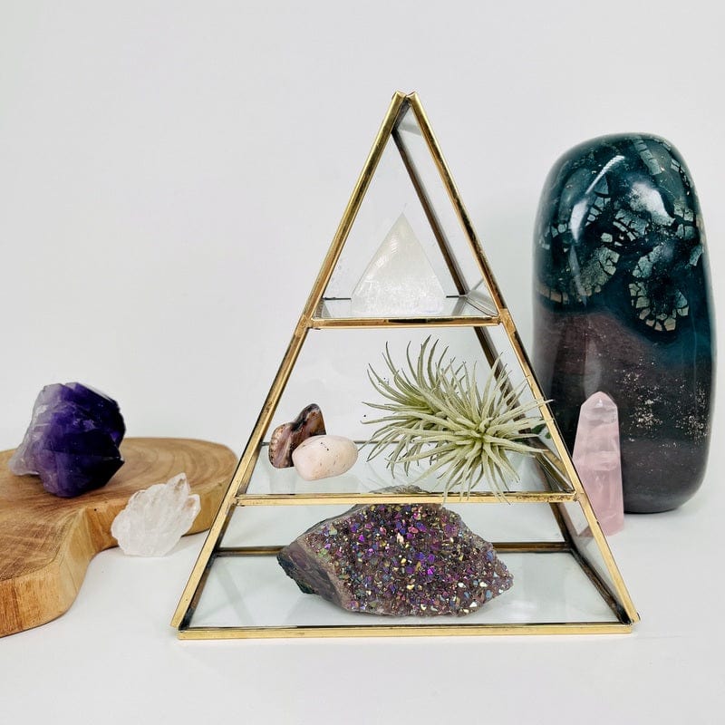 brass and glass pyramid crystal display set up as home decor 