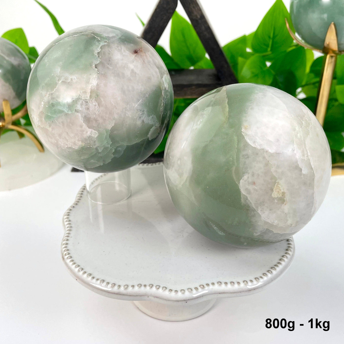two 800g - 1kg green and white quartz spheres on display for possible variations