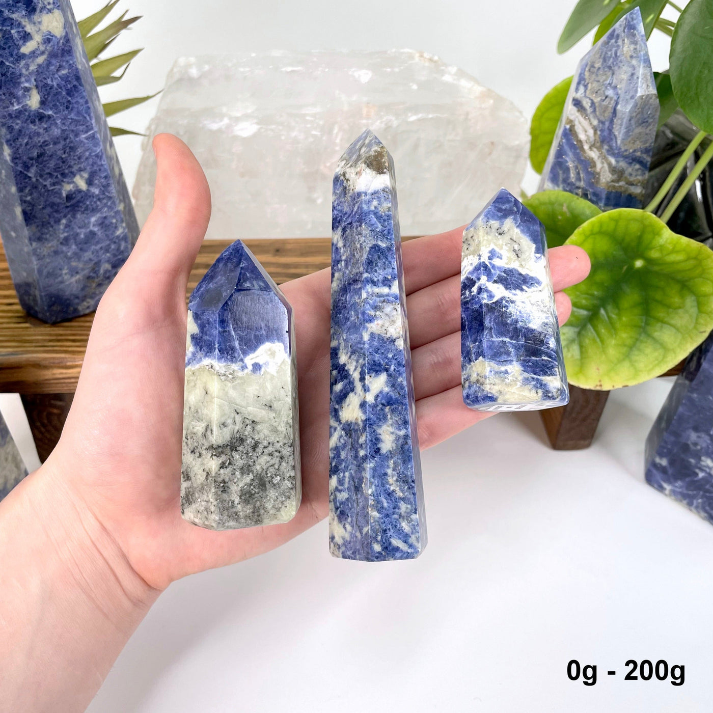 three 0g - 200g sodalite polished points in hand for size reference and possible variations