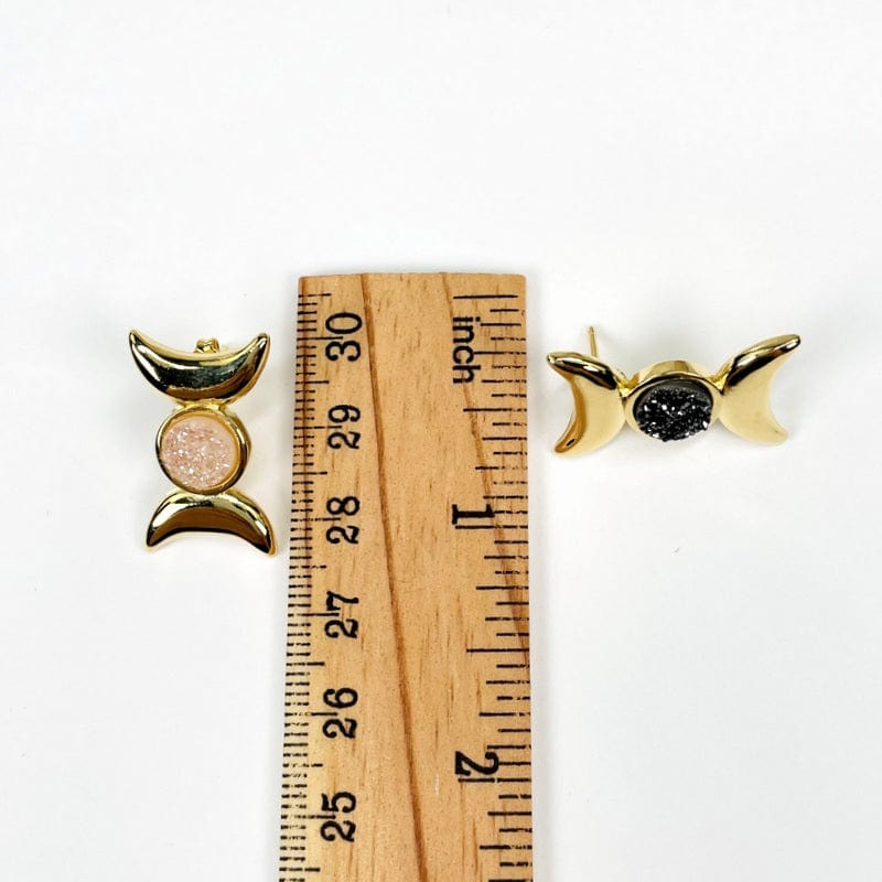 earrings next to a ruler for size reference 