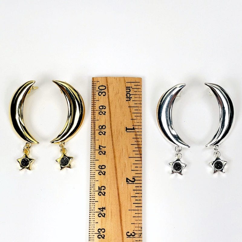 earrings next to a ruler for size reference. available in gold or silver 