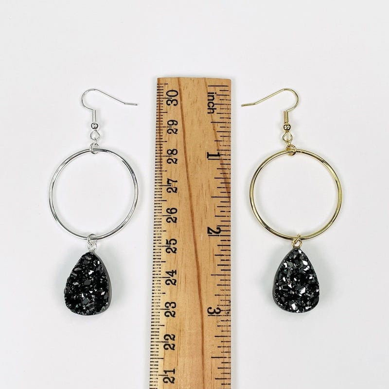 earrings next to a ruler for size reference 