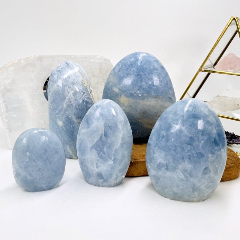 multiple blue calcite polished cut base stones displayed to show the differences in the sizes and color shades 