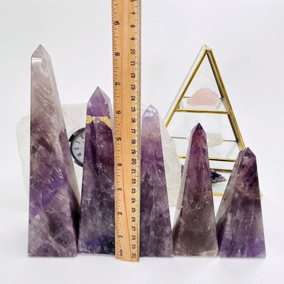 amethyst obelisk next to a ruler to show the differences in the tallness 