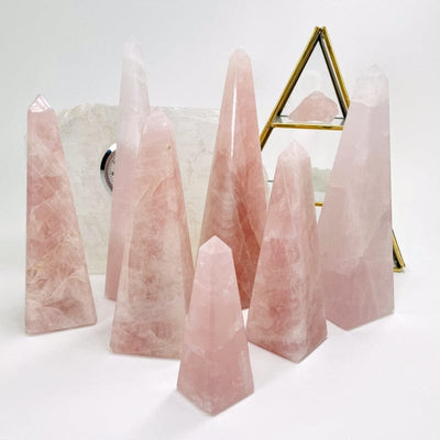 multiple rose quartz obelisk displayed to show the differences in the sizes and pink color shades 