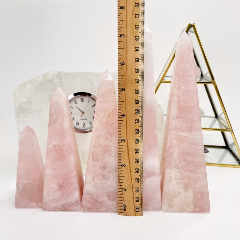rose quartz obelisk next to a ruler for size reference