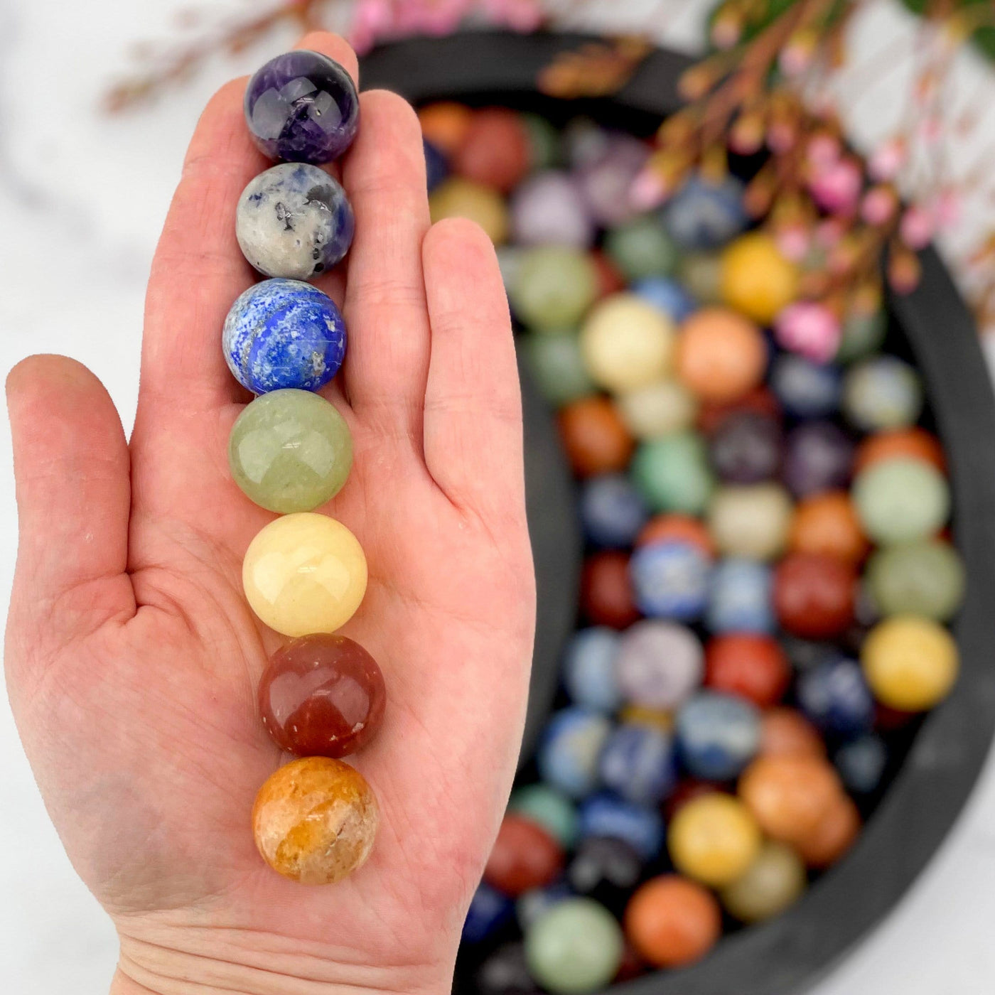 Chakra Sphere Set in a hand above a lot of others in a moon shaped bowl