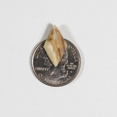 Mexican onyx diamond shaped cabochon on quarter for size reference