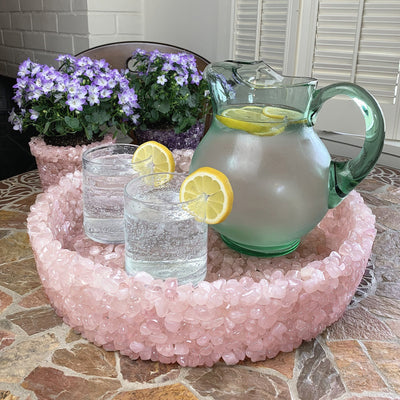 tumbled rose quartz stone bowl with a pitcher and 2 glasses in it
