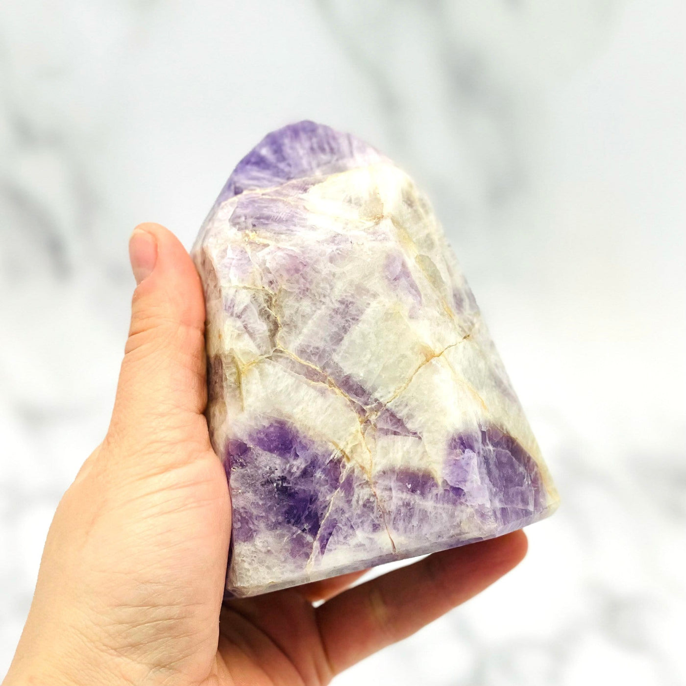 hand holding up Chevron Amethyst Polished Point 