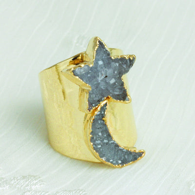 angled view of star and moon druzy ring on white background