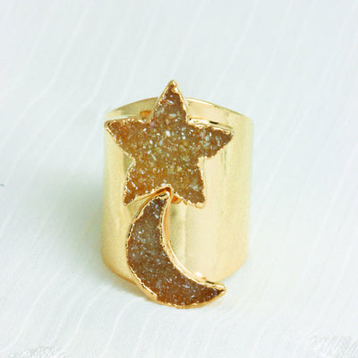 up close shot of star and moon druzy ring on white background