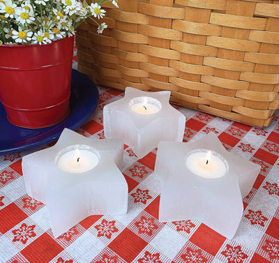 three selenite star candle holder on display with candles (not included with purchase) 