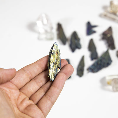 hand holding titanium treated kyanite blade with others blurred in the background
