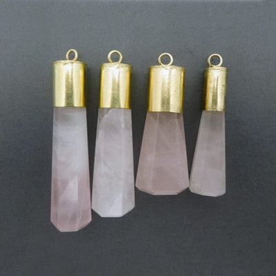 4 Rose Quartz Point Pendants of different sizes lined up on black background