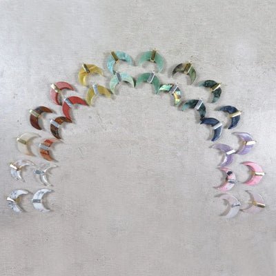 various crescent pendants in a semi-circle formation on gray background
