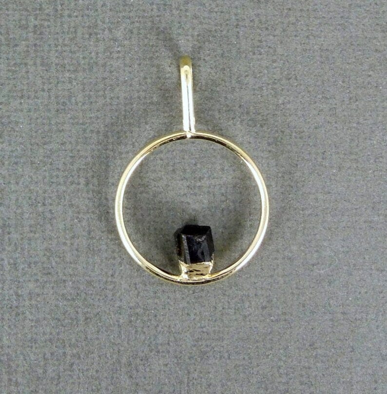 up close shot of tourmaline pendant on gray background