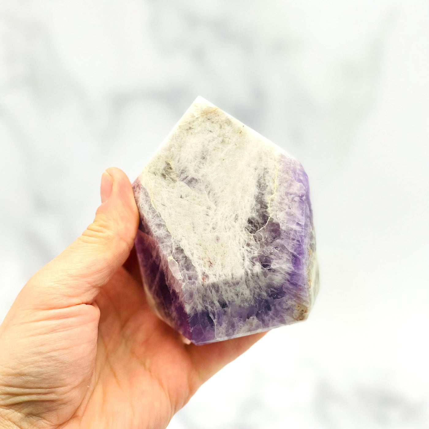 hand holding up Chevron Amethyst Polished Point