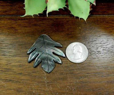 Abalone - Black Mother Of Pearl Leaf Bead - next to a quarter