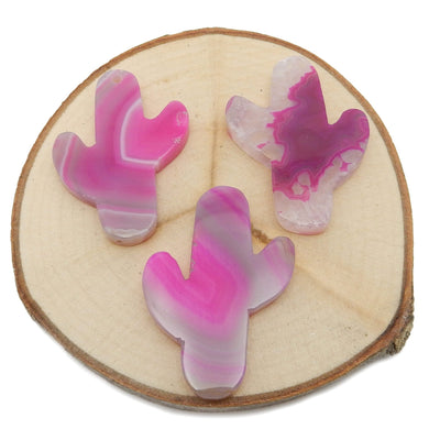 This picture is showing 3 of our pink cactus agates, being displayed on a wooden platform. 
