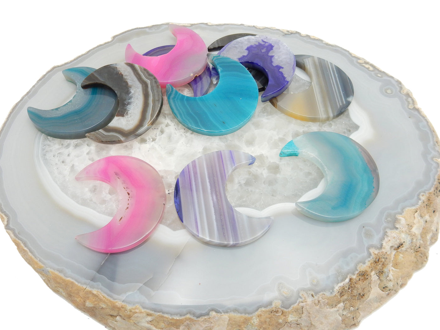 Some agate moons are being displayed on a crystal quartz platter.