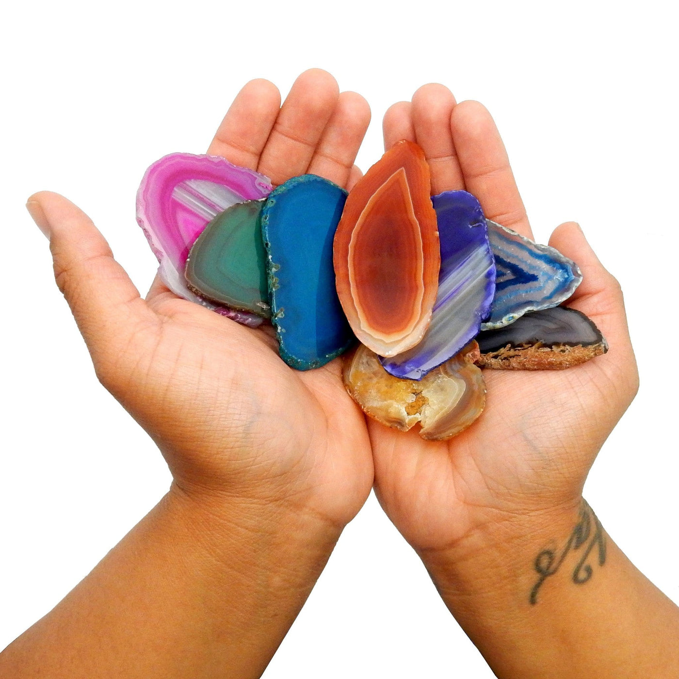 This Picture is showing all the variety of colors we have for our size 0 agate slices, also being displayed in hands. 