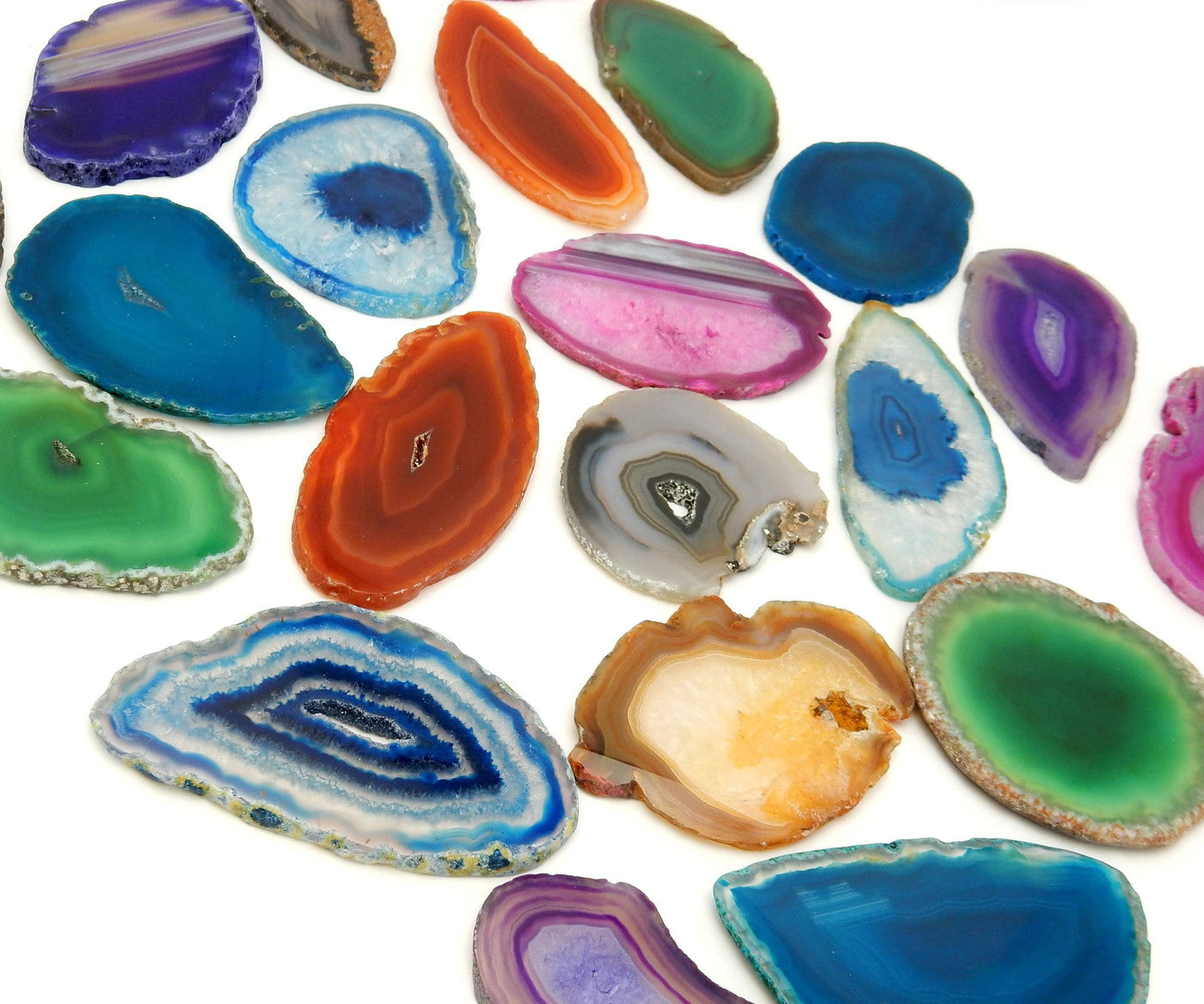 This Picture is showing the multiple colors we have available for our size 0 agate slices, also being displayed on a white background.