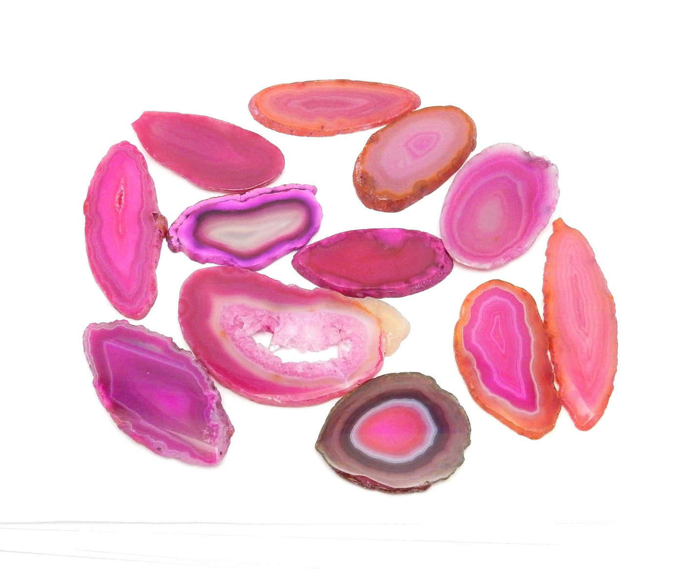 Pink agate slices being displayed on a white back ground.