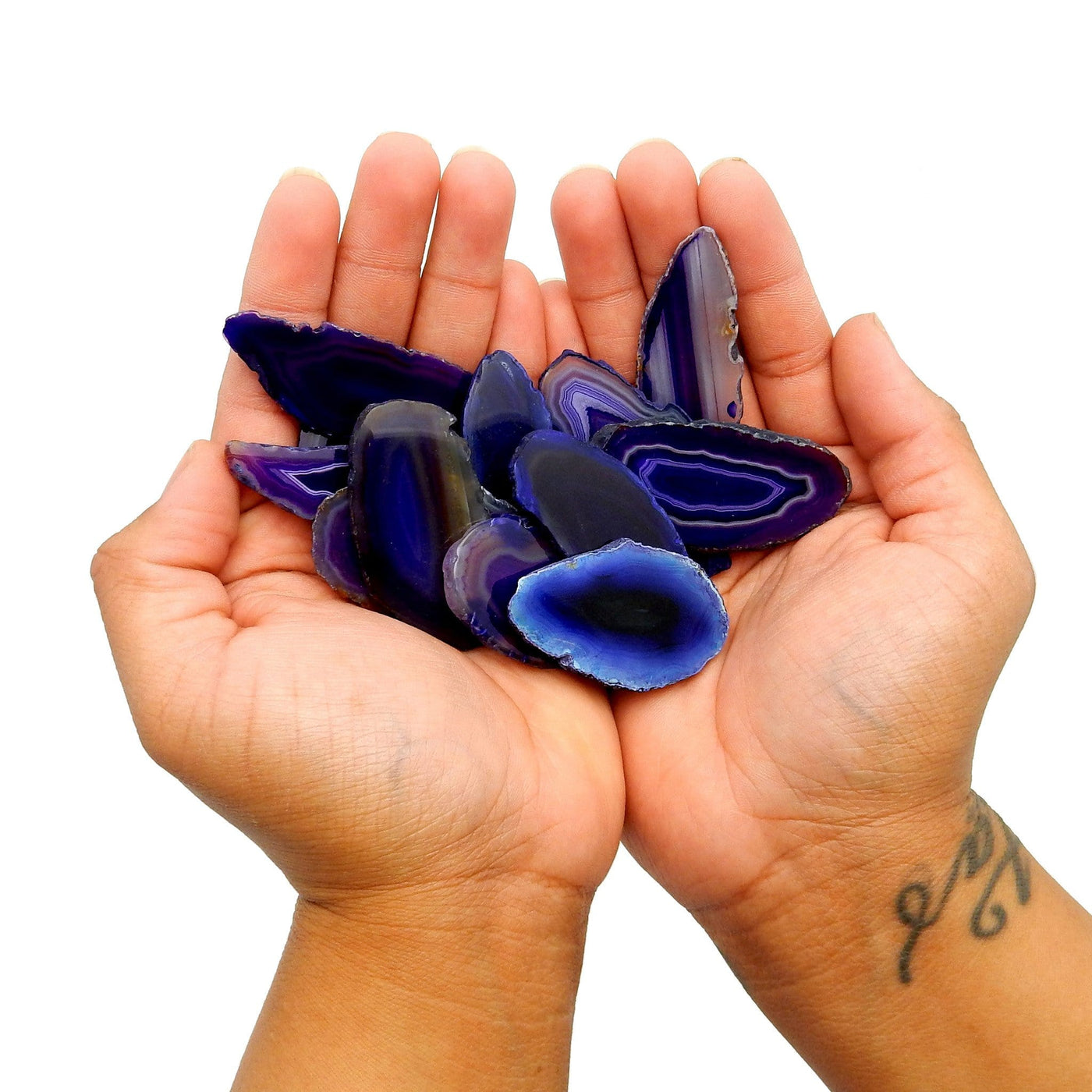 This Picture is Showing Purple agate slices in hands for size reference and display.