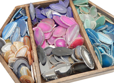 all variety of colors for our agates are being displayed on a dark brown tray.