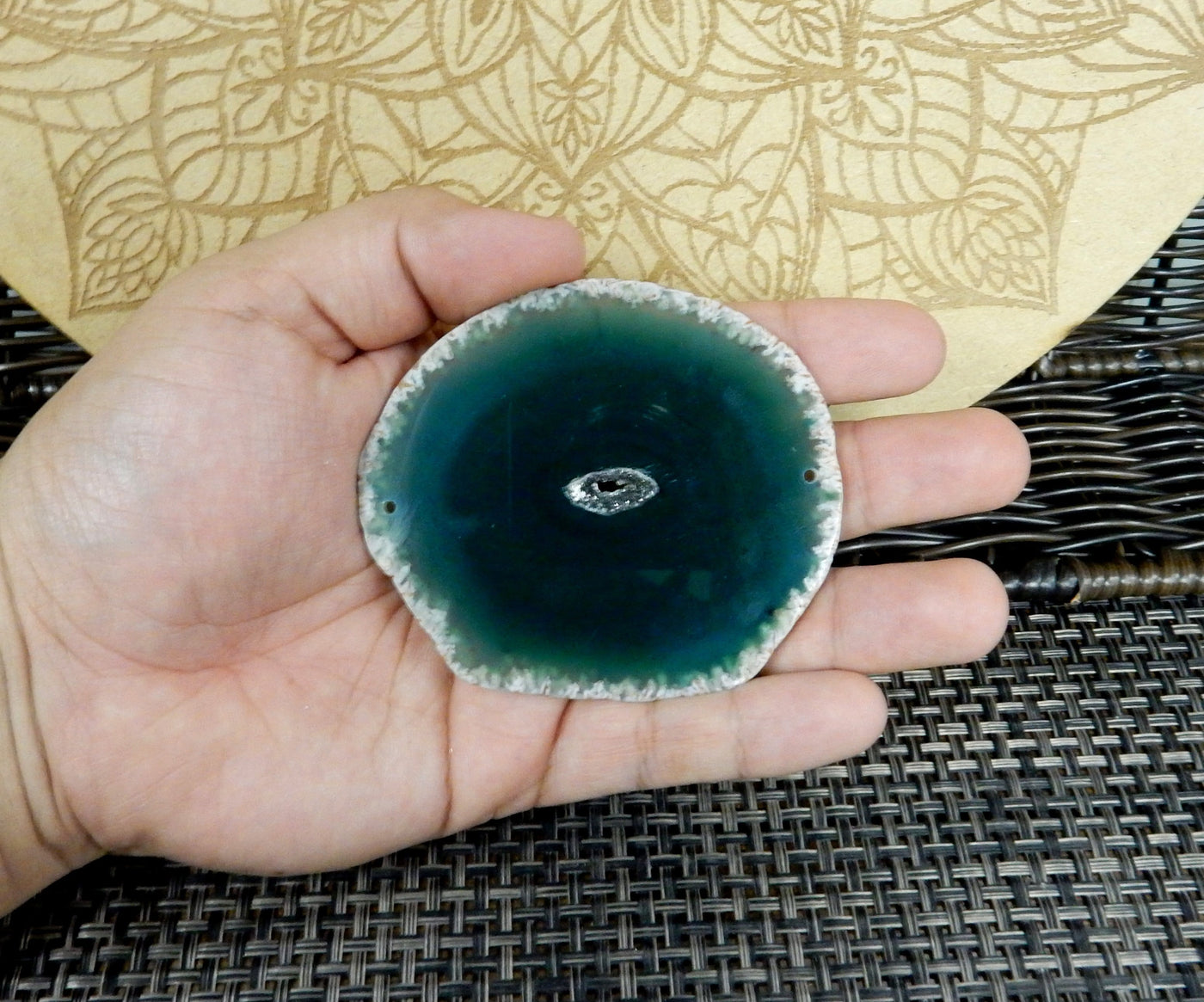 green agate slice being held for size reference.