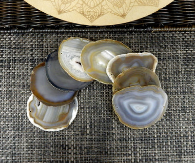 natural agate slices being displayed on a dak brown background.