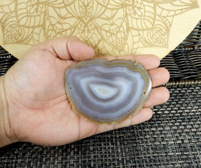 natural agate slice being held for size reference.