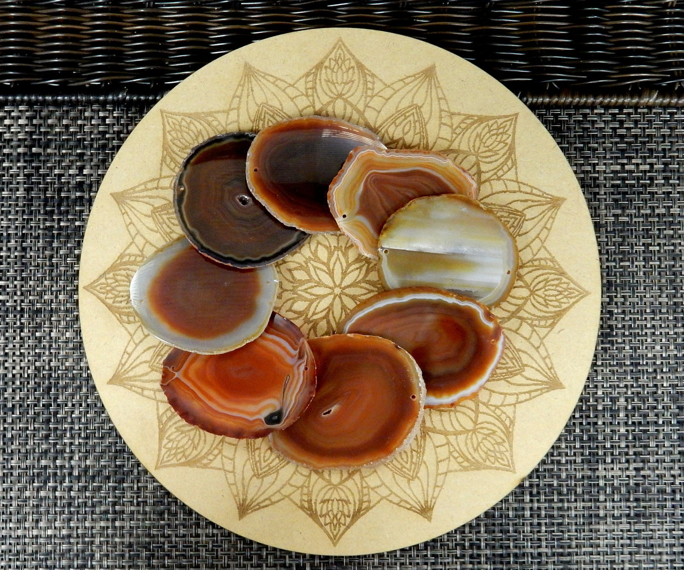 red/orange agate slices being displayed on a wooden grid.