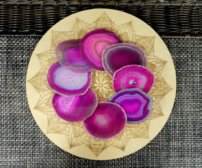 Picture of multiple pink agate slices, being displayed on a wooden grid