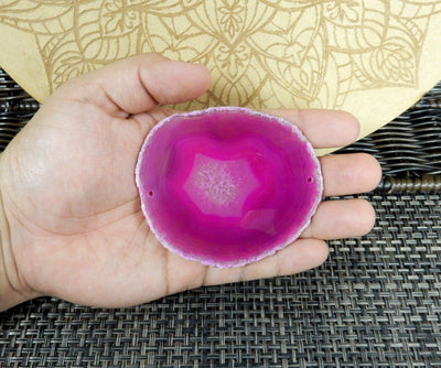 pink agate slice is being held for size reference.