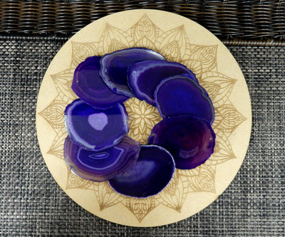 purple agate slices being displayed on a wooden grid.