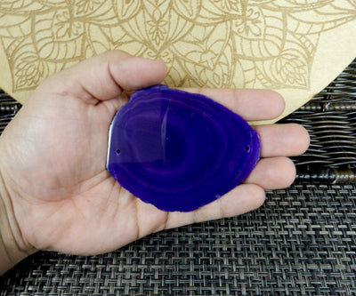 agate slice being held for size reference.