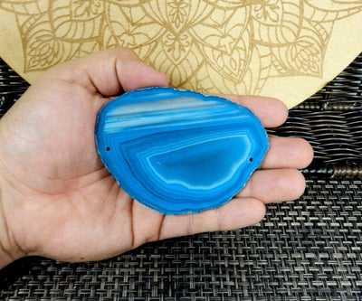 blue agate slice being held for size reference.