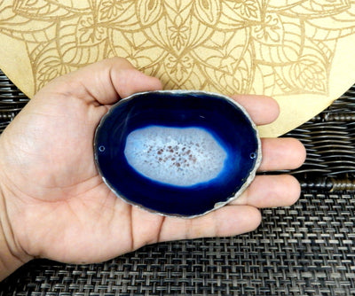 Blue agate slice being held for size reference.