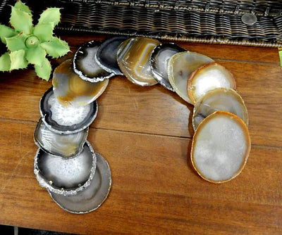Natural agate slices being displayed on a dark brown background.