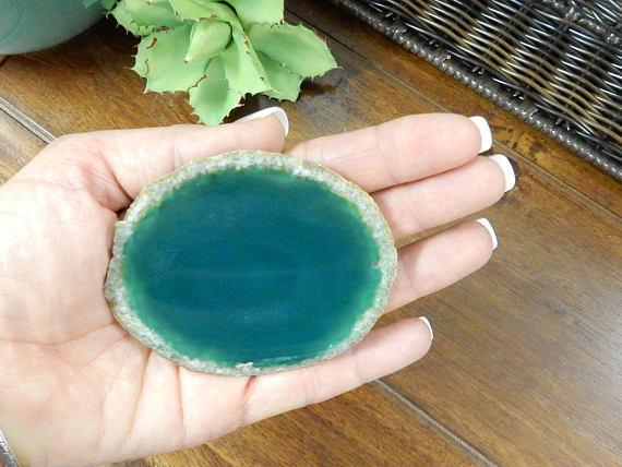 Picture of one green agate slice being held, for size reference.