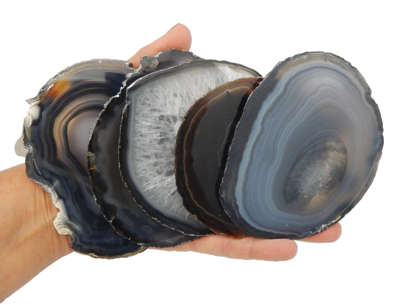Hand holding up 5 of the Black Agate slice 